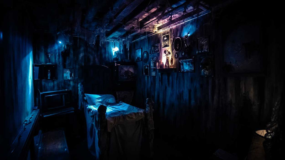 Eerie blue-lit bedroom with an unmade bed, framed pictures, and glowing wall lights in a dark, creepy room.