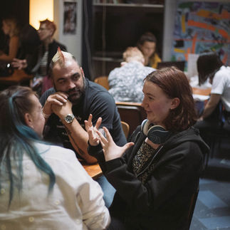 Three people converse around a table