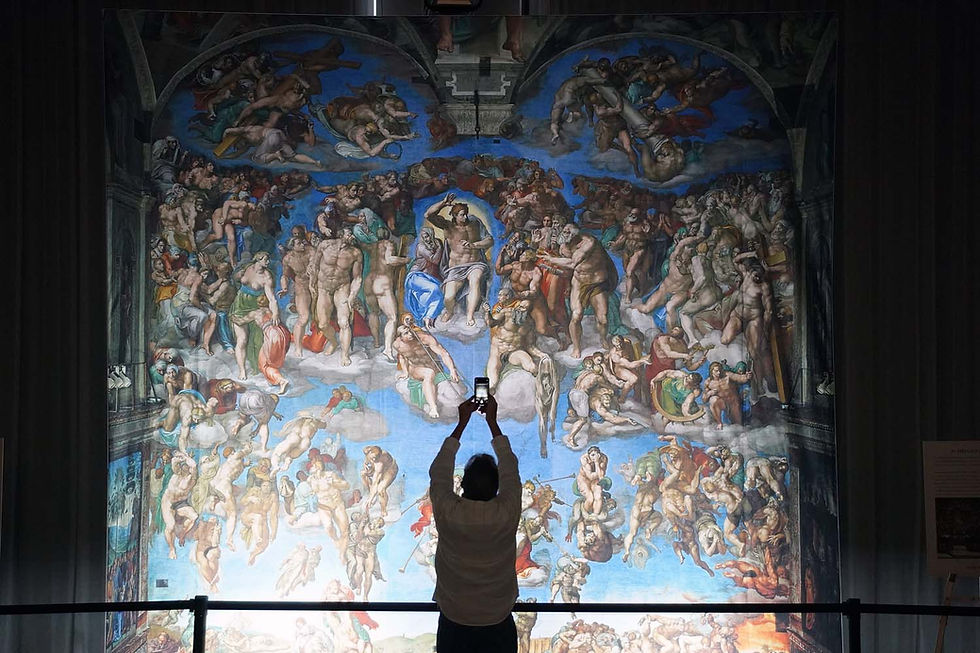 A person photographs the vibrant "Last Judgment" fresco with a smartphone in an art museum setting, capturing its dynamic scenes.