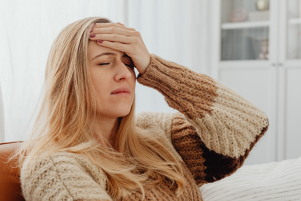 Woman holding her forehead while suffering from migraine