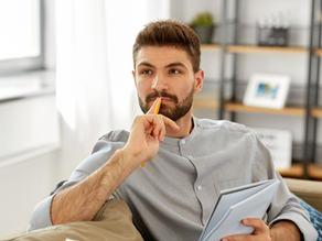 Man writing to notebook and thinking at home about choosing which IV therapy is best for him