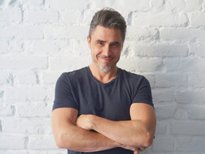 Portrait of a mature man smiling with white bricks background