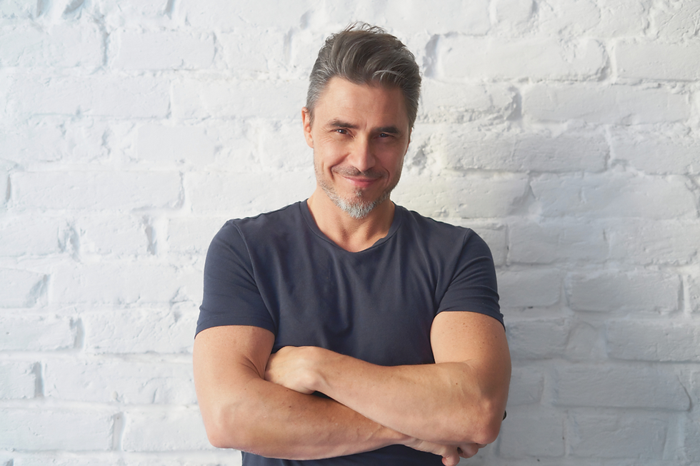 Portrait of a mature man smiling with white bricks background