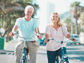 Happy senior couple riding bicycles outdoors
