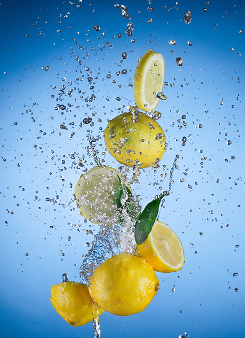Lemon with water splash on blue background.png