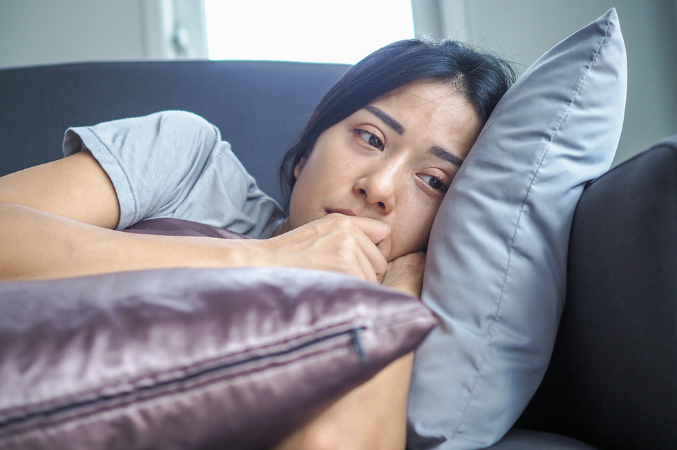 Unhappy and depressed woman laying on the couch at home