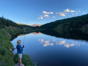 Blonde young girl fishing in a river