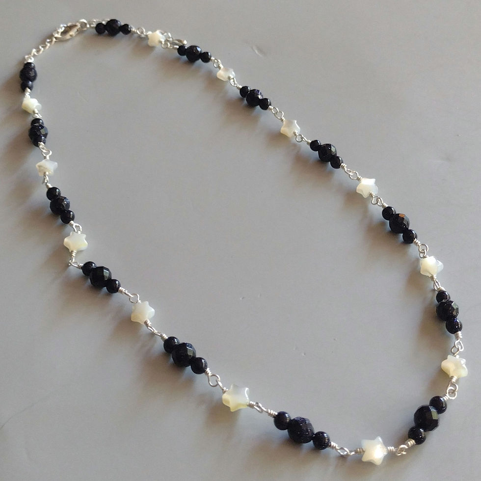 A rosary style chain necklace with blue goldstone and white mother of pearl stars.