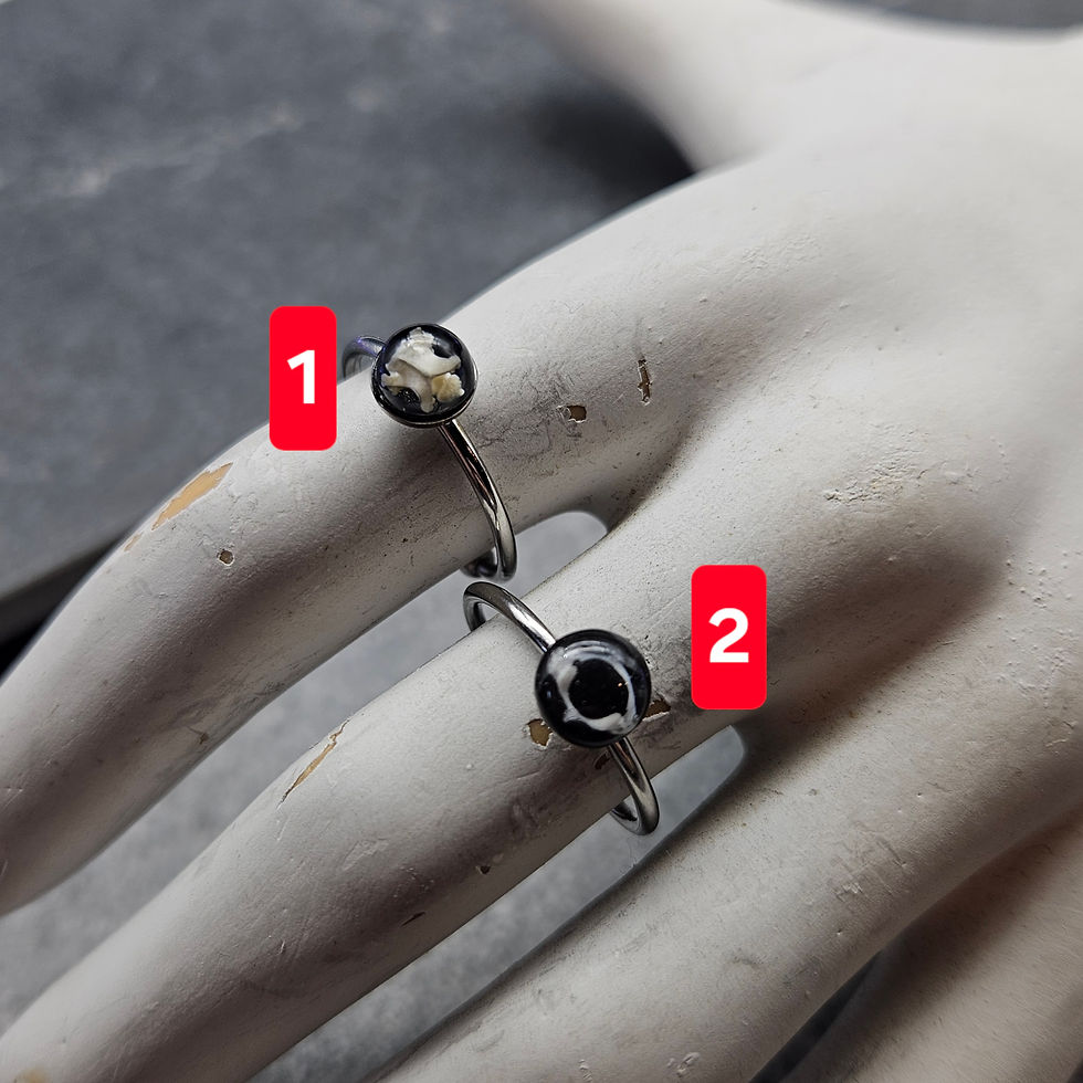 Silver-toned steel adjustable rings set with small cabochons of mouse bones in resin
