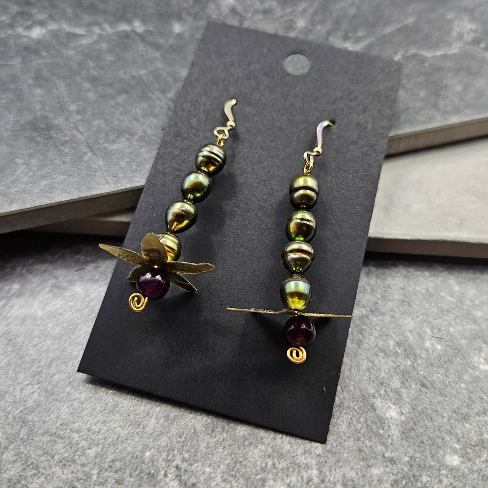 A pair of sequin and stone earrings in blues, purples, and greens.