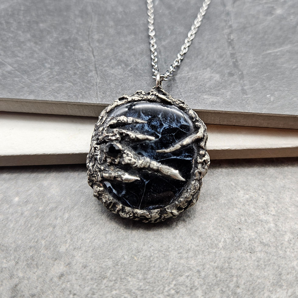 Pendant with stormy gray glass cabochon with silver soldered design.