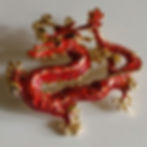 A brooch with a twining red dragon