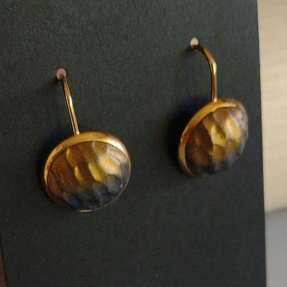 Gold earrings with round dragon skin texture cabochons in gold and black.