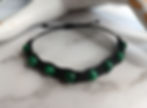 A simple black macrame bracelet with green malachite beads