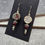 Thumbnail: Earrings with ceramic focals featuring a burgundy cat and "Cats, Naps, and Snacks" with burgundy beads and silver accents
