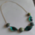 Gold chain necklace with large green crystal beads and intricate round rainbow beads that change color with body heat.