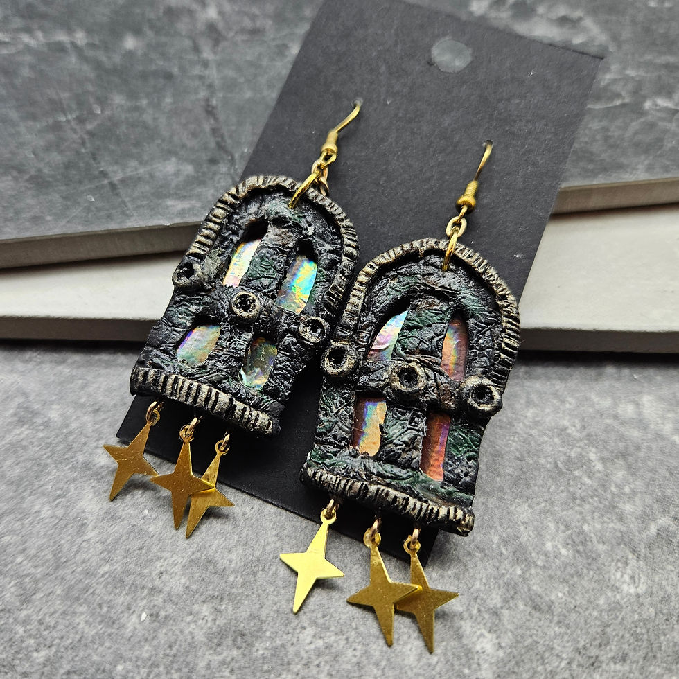 Earrings resembling cathedral windows with gold stars dangling beneath.