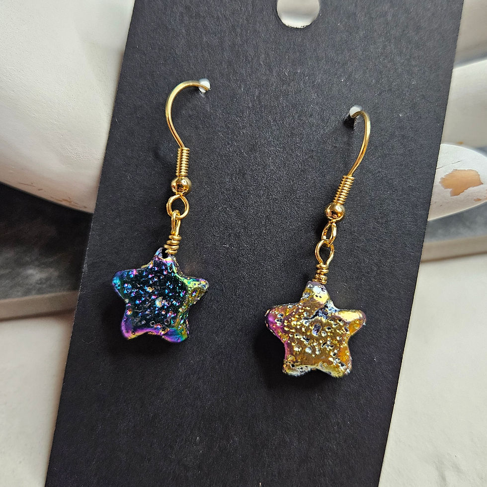 Rainbow lava stone star earrings on gold tone ear hooks.