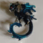 A teal dragon brooch that can double as a pendant.