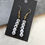 Thumbnail: Letter bead earrings that spell out "tired" on gold toned ear hooks