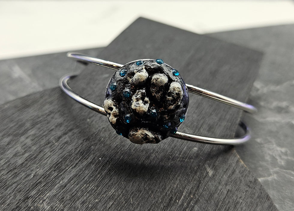 Two-wire bangle bracelet with a skull cabochon studded with blue crystal