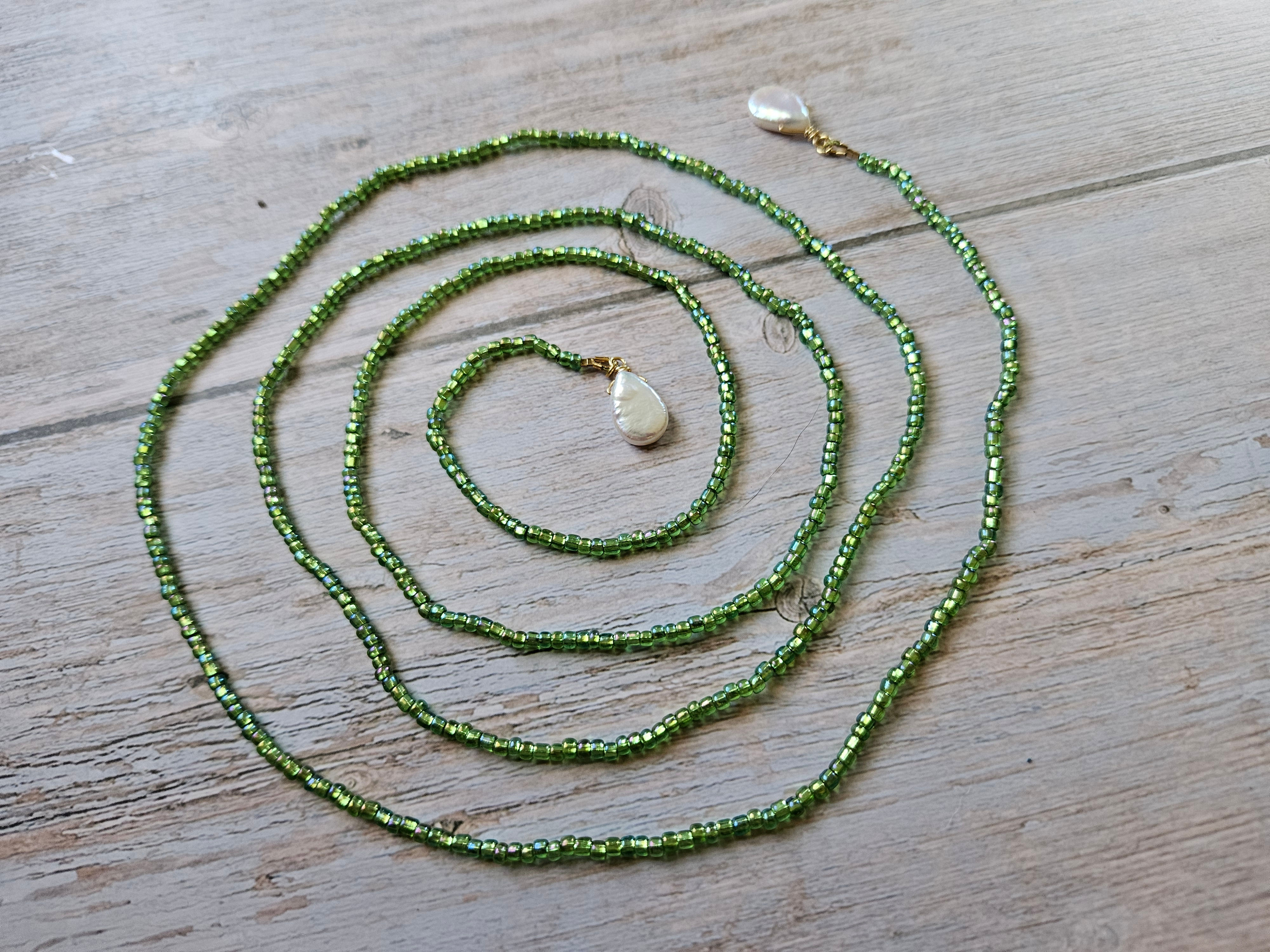 A green glass bead lariat with two teardrop pearls