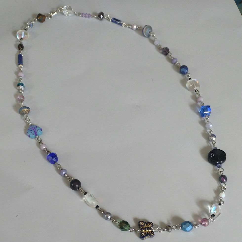 Rosary style necklace with various Czech glass beads in cool blue tones with coordinating beads.