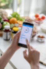 woman-professional-nutritionist-working-checking-data-from-smartphone-with-variety-fruits-