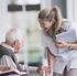 A young worker smiling with an elderly man