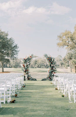view of the wedding Arbor with white ceremony chairs