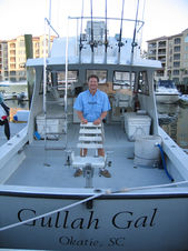 Captain poses for a picture next to the fishing seat in the stern of the Gullah Gal boat