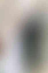 bride holding her chest smiling at the groom reading his vows during the ceremony