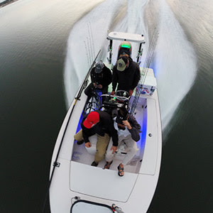 aerial view of four men on a fishing boat speeding fast