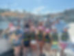 large group of guests on the dock in front of the boat at the marina