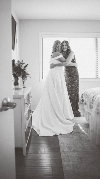 bride and mother side hugging in black and white
