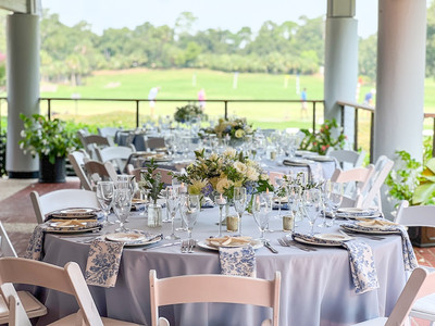 round tables with light blue tablecloths and white and blue accents set up for a wedding at The Veranda