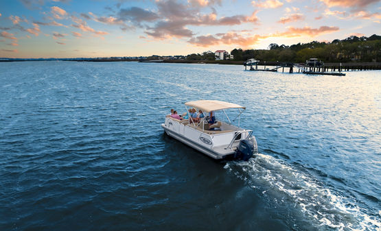 aerial view of the back of the pontoon boat as it leaves the marina in the sunset