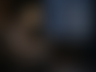 Man sitting in a chair late at nigh with it snowing outside. Why Winter Makes Sleep and Stress Worse.