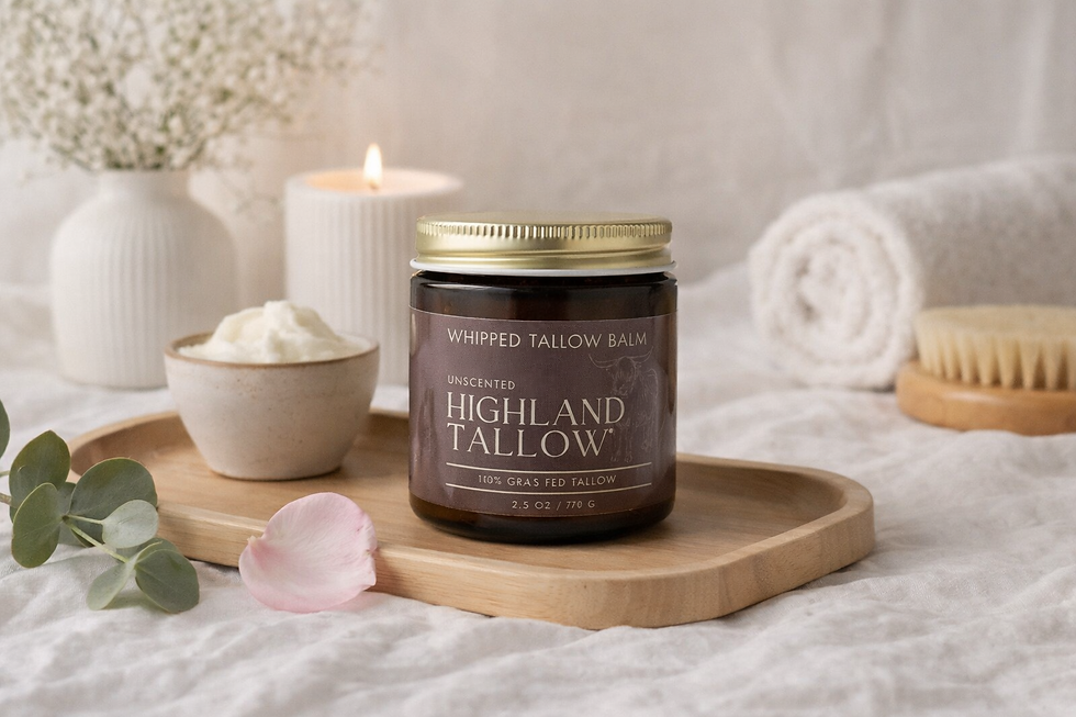 Jar of Highland Tallow Co. Whipped Tallow Balm on a wooden tray with a small bowl of tallow surounded by bath/spa items such as a candle and towel