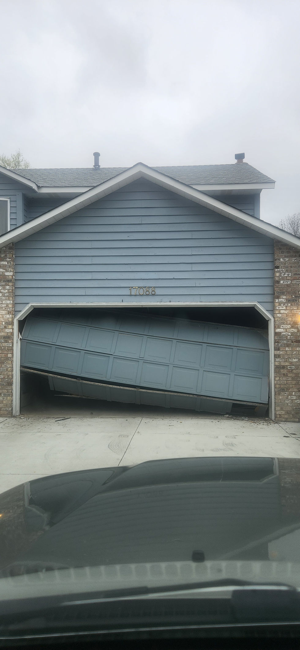 BEFORE — Damaged garage door