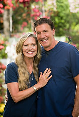 A picture of a blonde woman and brunette man smiling in blue scrubs.