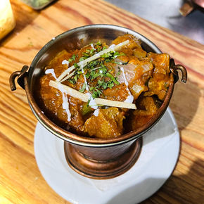Indian curry with ginger and cilantro in a copper bowl