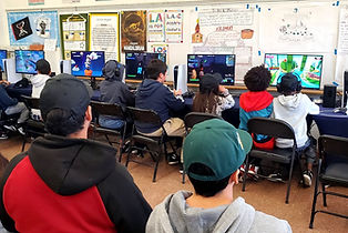 Students playing at GameLand stations inside a classroom