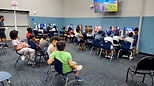 Rows of kids at GameLand stations in a large community room