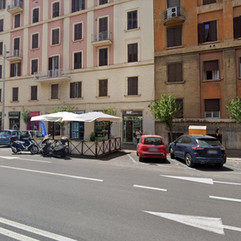 Street view of MAE cafe in Rome’s Prati district, with outdoor seating and storefront signage.