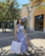 A woman walks through Castel Romano Designer Outlet with Caractère and other shopping bags in hand, illustrating a successful day of outlet shopping in Rome.