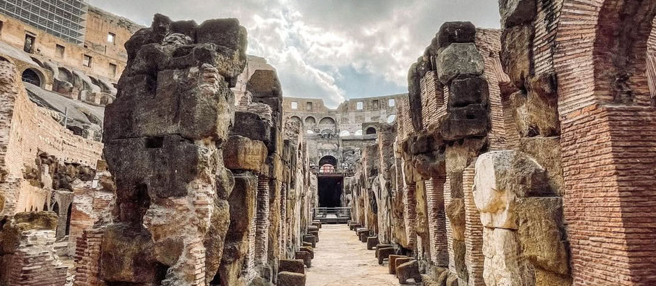 View down the stone corridor of Rome’s Colosseum hypogeum, showing ruined pillars where lifts and animal cages once stood.