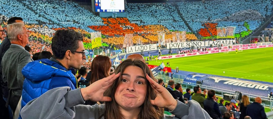 Football match with a local in Rome: smiling fan in the stands at Stadio Olimpico with Lazio Curva Nord choreography in the background during the Rome derby. Photo: ila_limelli