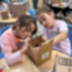 Sinai Learning Lab students exploring objects together during a hands-on social studies activity.