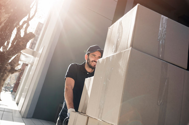 happy-delivery-man-with-parcels-on-sidew